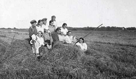 Колхоз им.Сталина. Колхозница А.К. Архипцева читает газету товарищам во время перерыва на сенокосе. 1949 год.